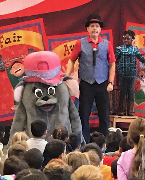 Doug Scheer presents an oversized story of Aesops Fable to teach respect during a Diversity Circus Assembly Show.