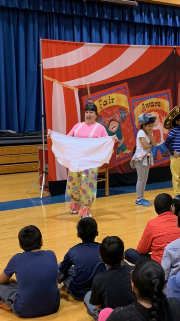 Doug Scheer presents an oversized story of Aesops Fable to teach respect during a Diversity Circus Assembly Show.